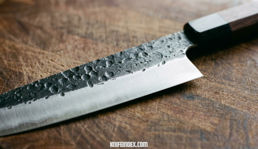 Close-up of a hand-forged chef knife with visible hammer texture on the blade spine